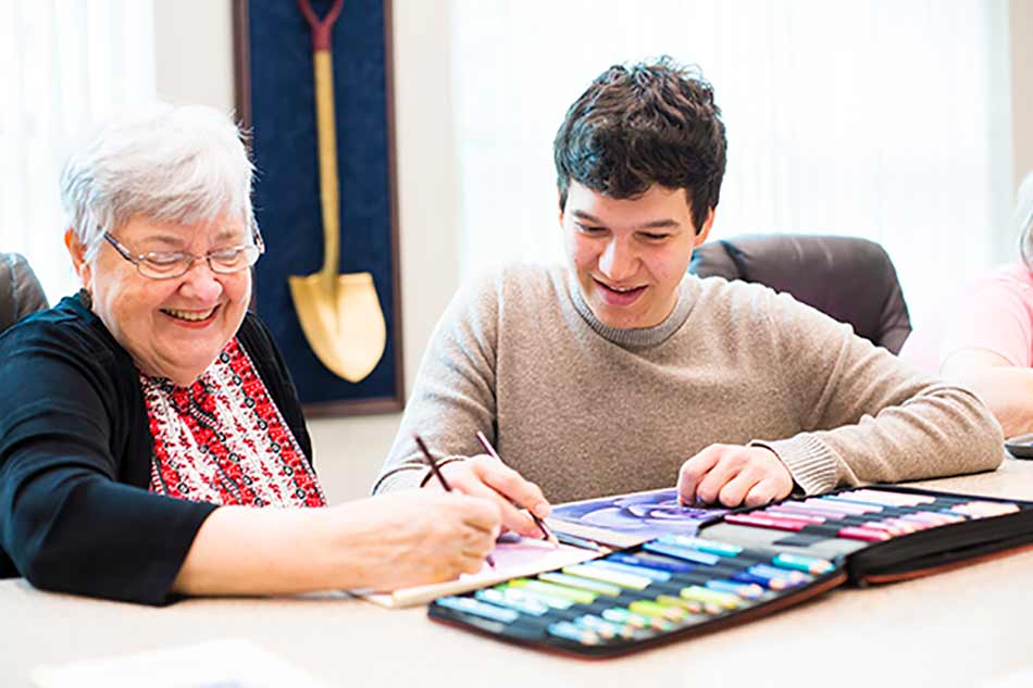 Oxford volunteers do art projects with members at a senior center.