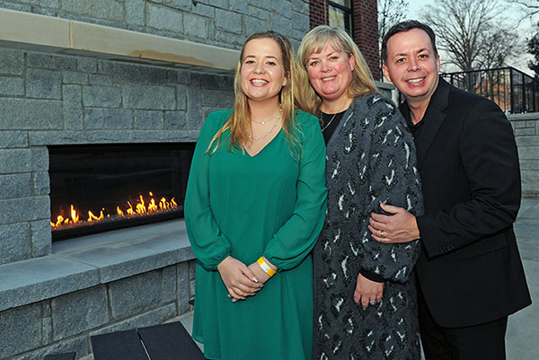 An alumni family at the outdoor fireplace at the Oxford student center