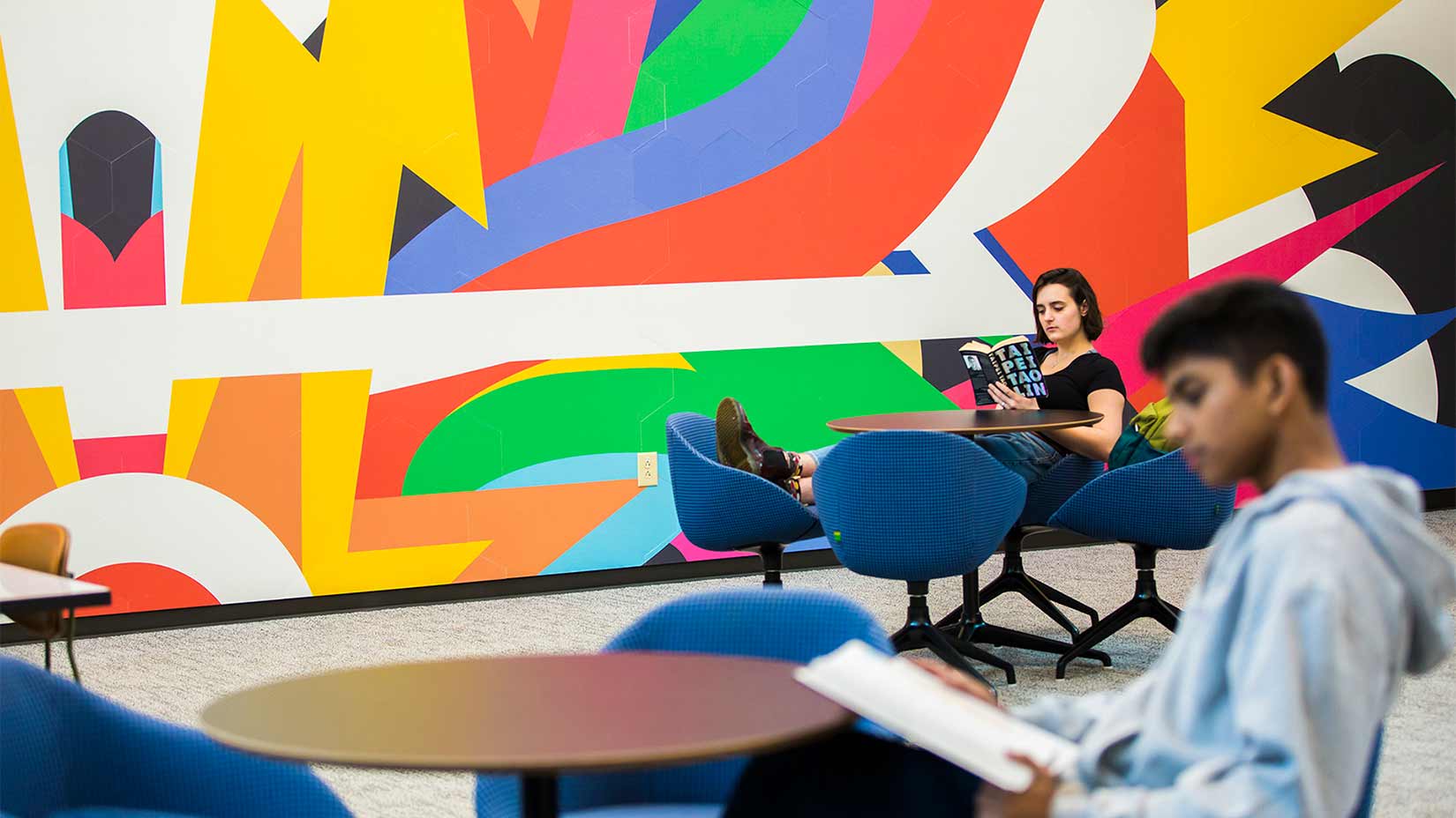 Students relax in the mural room of the student center. 