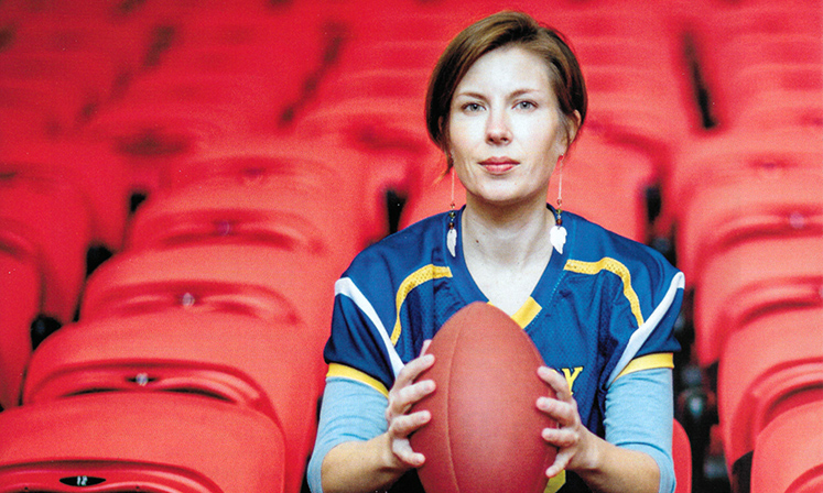 Erin Tarver poses with a football 