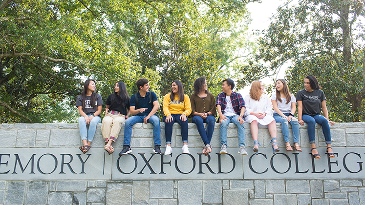 Oxford students on the main entrance wall to Oxford campus